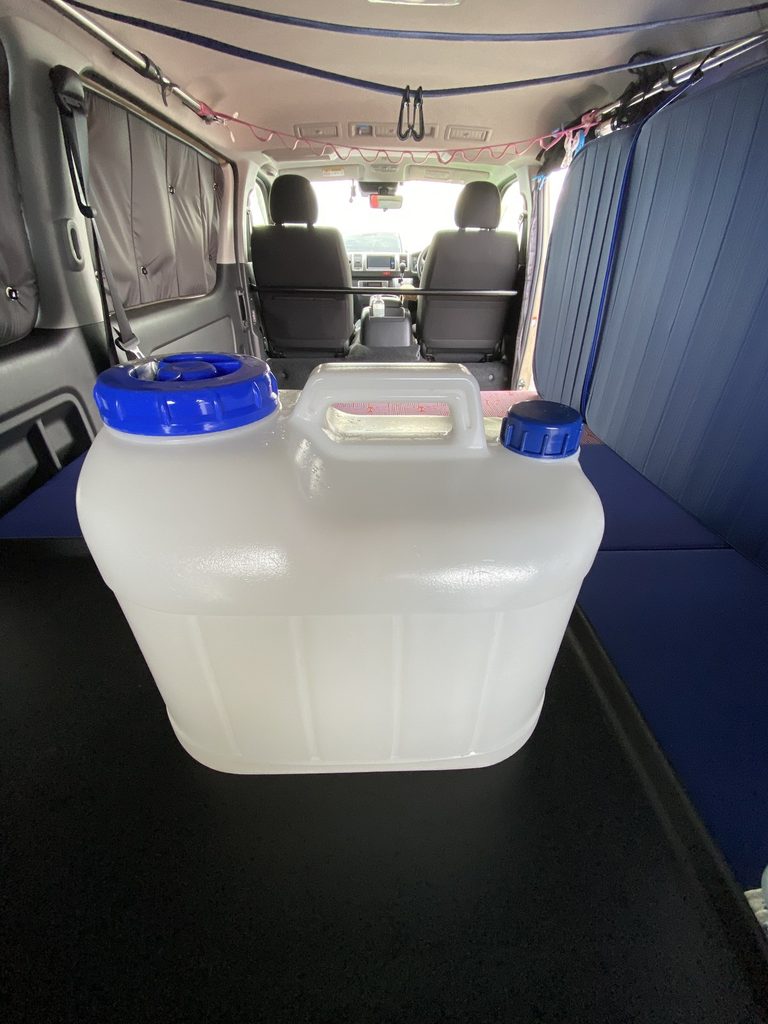 ハイエースの車内に積んだサーフィン用ポリタンクとシャワーキット